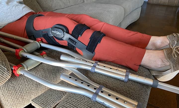 Patient in recliner with knee brace and crutches