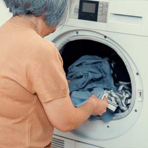 Lady taking a towel out of the dryer