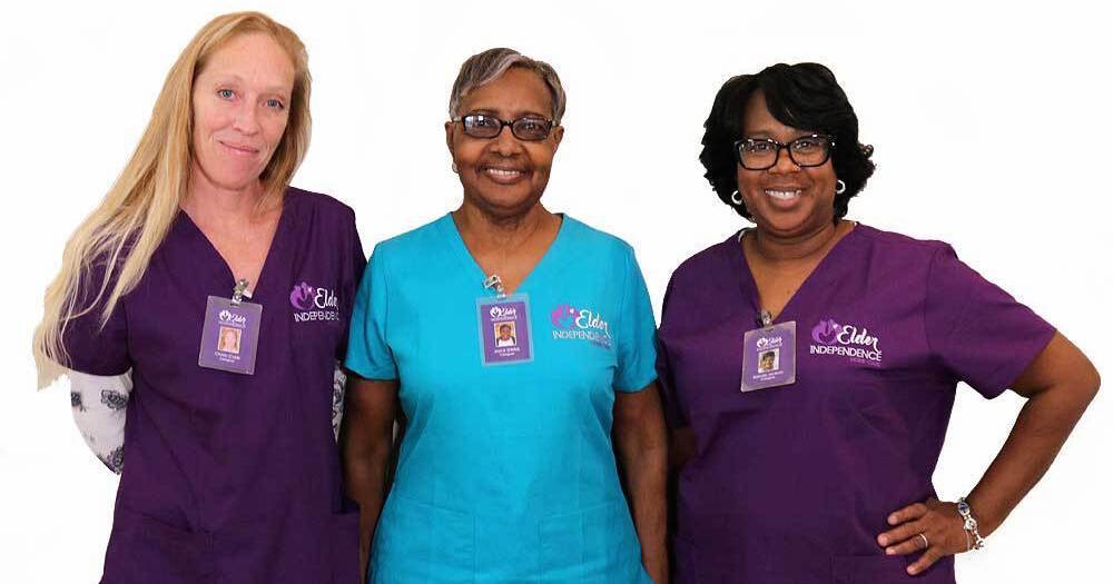 Three EIHC caregivers in uniform with name badges