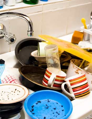 Dirty dishes piled up in the kitchen sink